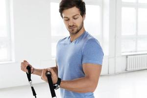 Young man during workout with a resistance bands in the gym photo