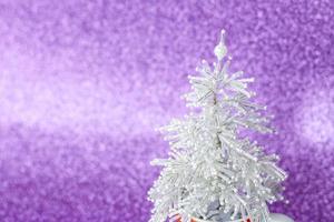 Snow-white, beautiful and very shiny Christmas tree made of beads. White Christmas tree on purple background. New year greetings, postcards, calendar. photo