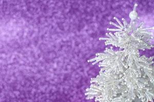 Snow-white, beautiful and very shiny Christmas tree made of beads. White Christmas tree on purple background. New year greetings, postcards, calendar. photo