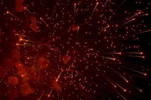 saludo. salpicaduras rojas y brillantes de fuegos artificiales en el cielo oscuro. foto