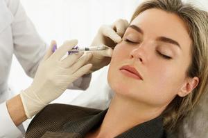 Woman during facial filler injections in aesthetic medical clinic photo