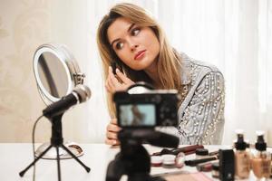 Woman beauty blogger using eyebrow tint gel during video recording for her followers photo