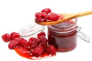 Jar of jam and raspberries on white background photo