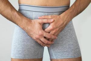 Young man suffering from penile pain photo