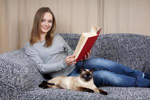 mujer joven con libro y gato foto