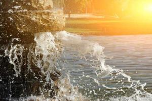 Pond spout with reflections of the sun behind. Horizontal image. photo