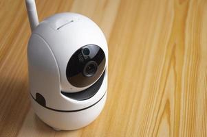 White IP camera placed on wooden floor photo