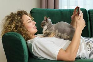 Young woman and her cute cat lying  on the sofa photo