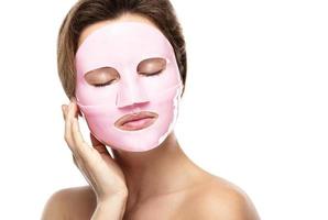 Young beautiful woman with rubber facial mask on her face photo