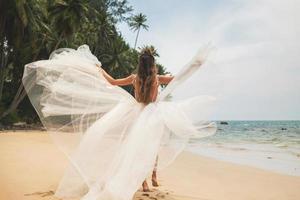 Bride wearing beautiful wedding dress on the tropical beach photo