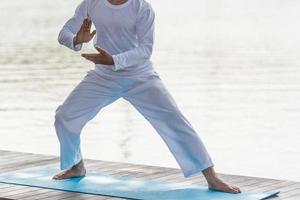 joven practicando el tradicional tai chi chuan, tai ji y qi gong en el parque para un concepto saludable y tradicional de artes marciales chinas sobre un fondo natural. foto