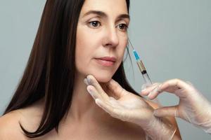 Middle aged woman receiving facial injection for skin rejuvenation photo