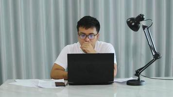 dipendente ha acuto indietro dolore nel posto di lavoro. stanco lavoratore uomo d'affari Lavorando nel ufficio seduta a computer scrivania lungo volta, asiatico attività commerciale uomo impiegato sindrome sedentario opera soffrire a partire dal male, dolore video