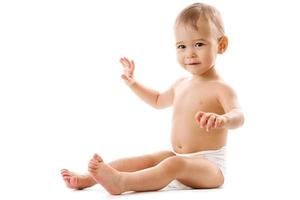 Curious healthy little boy in diaper sitting and smiling. photo