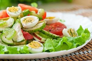 Salad of tomatoes, cucumbers and quail eggs photo