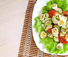 Salad of tomatoes, cucumbers and quail eggs photo