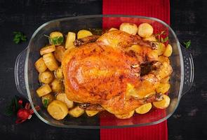 pavo o pollo al horno. la mesa navideña se sirve con un pavo, decorado con oropel brillante. pollo frito, mesa. cena de Navidad. vista superior, arriba foto