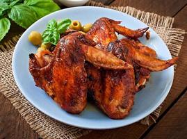 Plate of chicken wings on wooden background photo