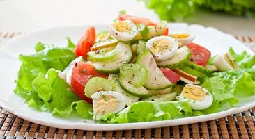 Salad of tomatoes, cucumbers and quail eggs photo