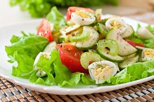 Salad of tomatoes, cucumbers and quail eggs photo