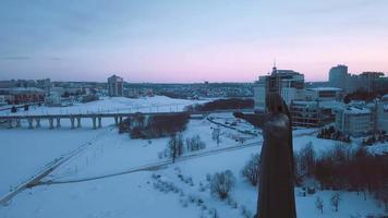 images aériennes de la vue hivernale sur le monument de la mère patronne avec le fond du soir sur le cheboksary enneigé, république chuvash, russie video