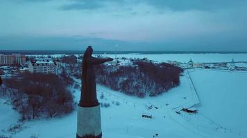 antenne beeldmateriaal van de winter visie naar moeder patrones monument met de avond achtergrond naar de besneeuwd cheboksary, tsjoevasj republiek, Rusland video