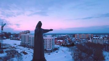luftaufnahmen des winterblicks auf das mutterschutzdenkmal mit dem abendhintergrund zum schneebedeckten tscheboksary, republik tschuwaschien, russland video