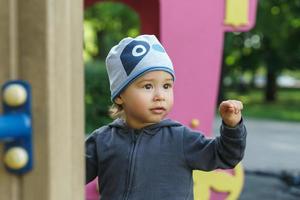 Cute little boy playing on a playground in a city park photo