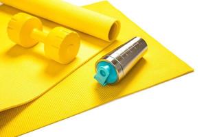 Yellow dumbbell, fitness mat and protein shaker photo