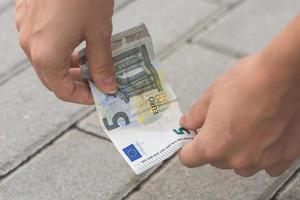 Woman is picking five euro banknote from the ground photo