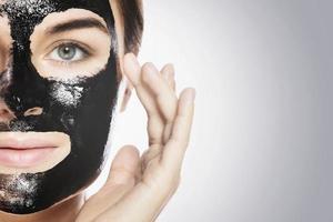 Woman with deep cleansing black mask on her face photo