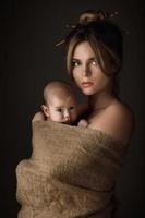 Beautiful mother and her little baby are wrapped in sackcloth photo