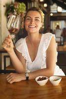 Beautiful and joyful woman with a glass of wine in a city cafe