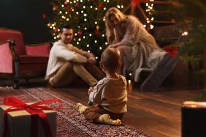 la joven familia feliz está celebrando navidad o año nuevo. foto