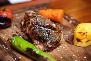 Grilled steak on a wooden plate photo