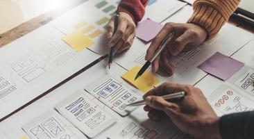 UI UX creative designer team designing wireframe layout for responsive mobile smartphone application in office photo