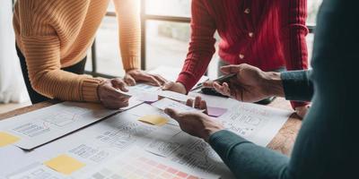 UI UX creative designer team designing wireframe layout for responsive mobile smartphone application in office photo