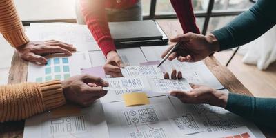 UI UX creative designer team designing wireframe layout for responsive mobile smartphone application in office photo