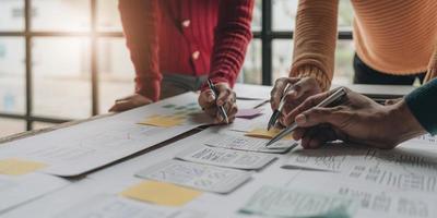 UI UX creative designer team designing wireframe layout for responsive mobile smartphone application in office photo