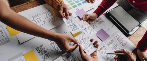 UI UX creative designer team designing wireframe layout for responsive mobile smartphone application in office photo