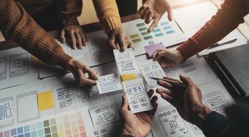 UI UX creative designer team designing wireframe layout for responsive mobile smartphone application in office photo