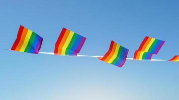 LGBT flag on blue sky background, it is a symbol of lesbian, gay, bisexual, and transgender  pride and LGBT social movements. Also known as the gay pride flag or LGBT. photo