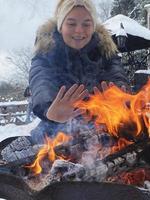 mujer calentándose las manos junto al fuego foto