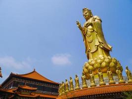 estatua de guanyin sobre fondo de cielo azul foto