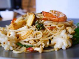 Close up spicy seafood spaghetti in grey dish photo