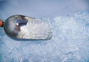 cuchara de hielo y hielo en el cubo foto