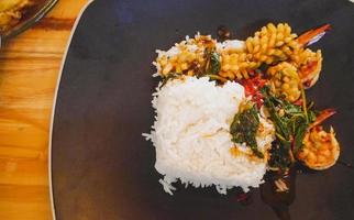 Spicy seafood with Jasmine rice in grey dish on wooden table photo