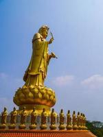 estatua de guanyin sobre fondo de cielo azul foto