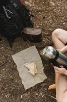 Hiker during her halt eating sandwich in green forest photo