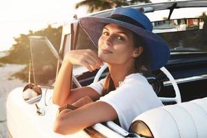 Happy young woman and retro convertible car photo